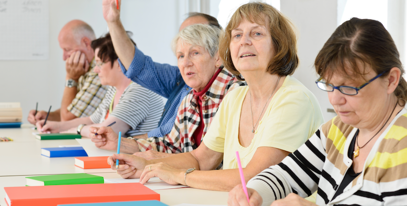 Elderly people at a workshop sitting at table making notes