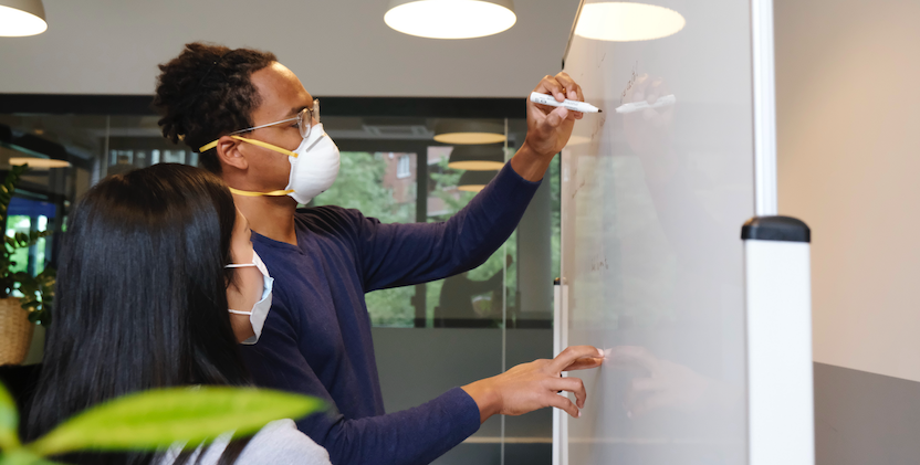 Two people working on a whiteboard