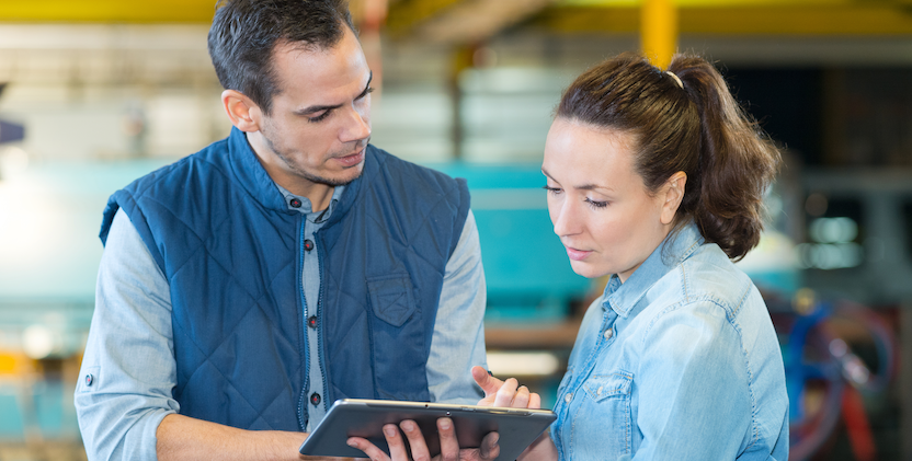 Man and women looking at tablet in a factory