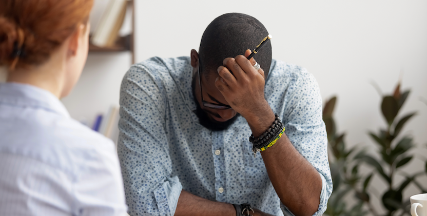 Man sitting at desk with head in hands