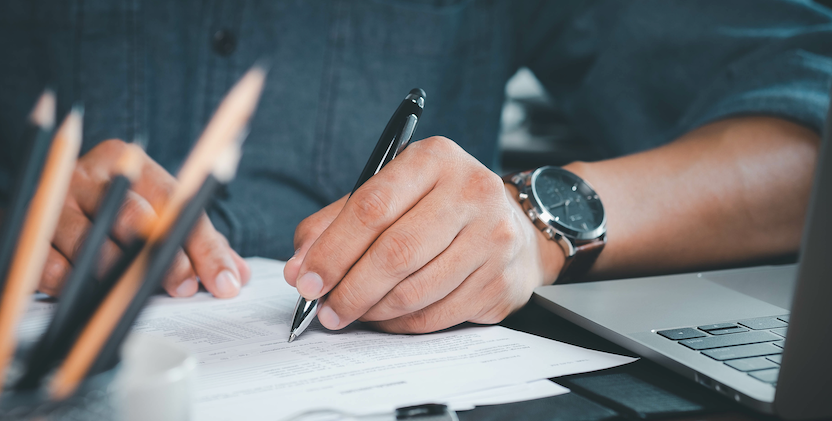 Image of mans hand making notes on a form