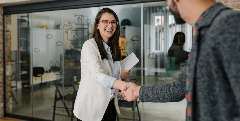 Business women shaking mans hand outside office